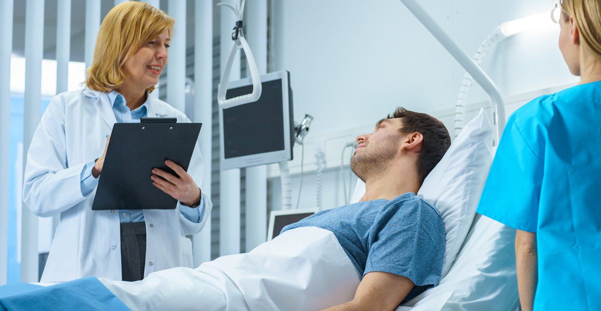 Female-doctor-visiting-recovering-male-patient Female-doctor-visiting-recovering-male-patient