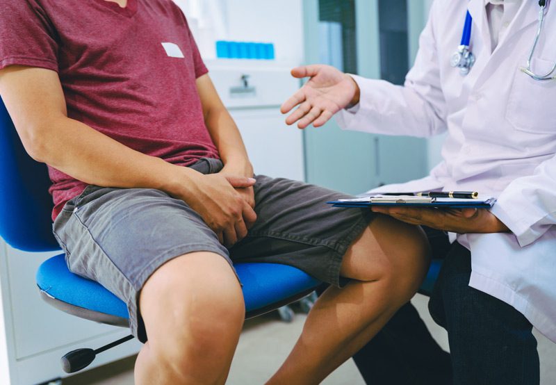 man-discussing-symptoms-with-doctor man-discussing-symptoms-with-doctor